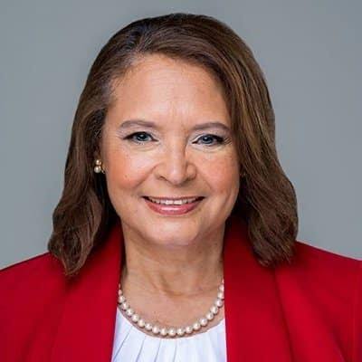 A woman with a red blazer and white shirt.